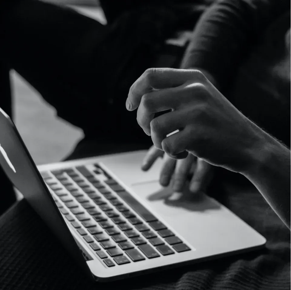 Student typing on a laptop during an online class